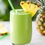 avocolada tropical smoothie recipe in glass with pineapple and coconut